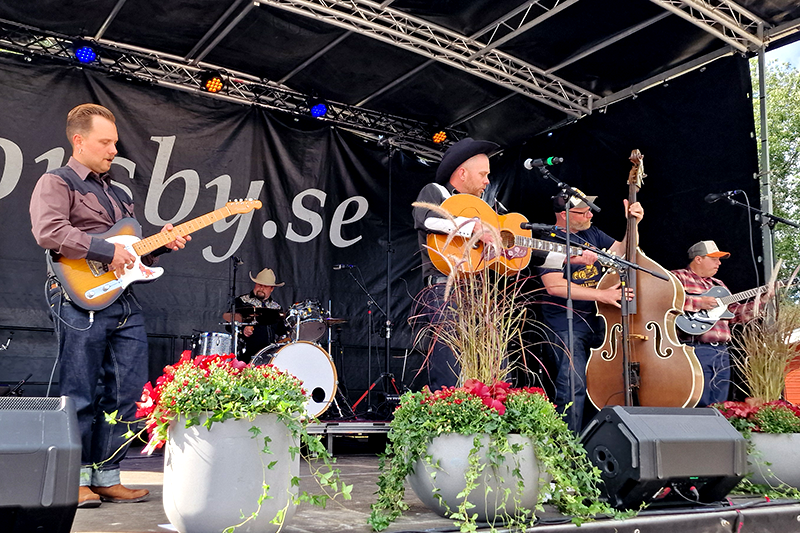 Musikband med fem personer på en scen. 